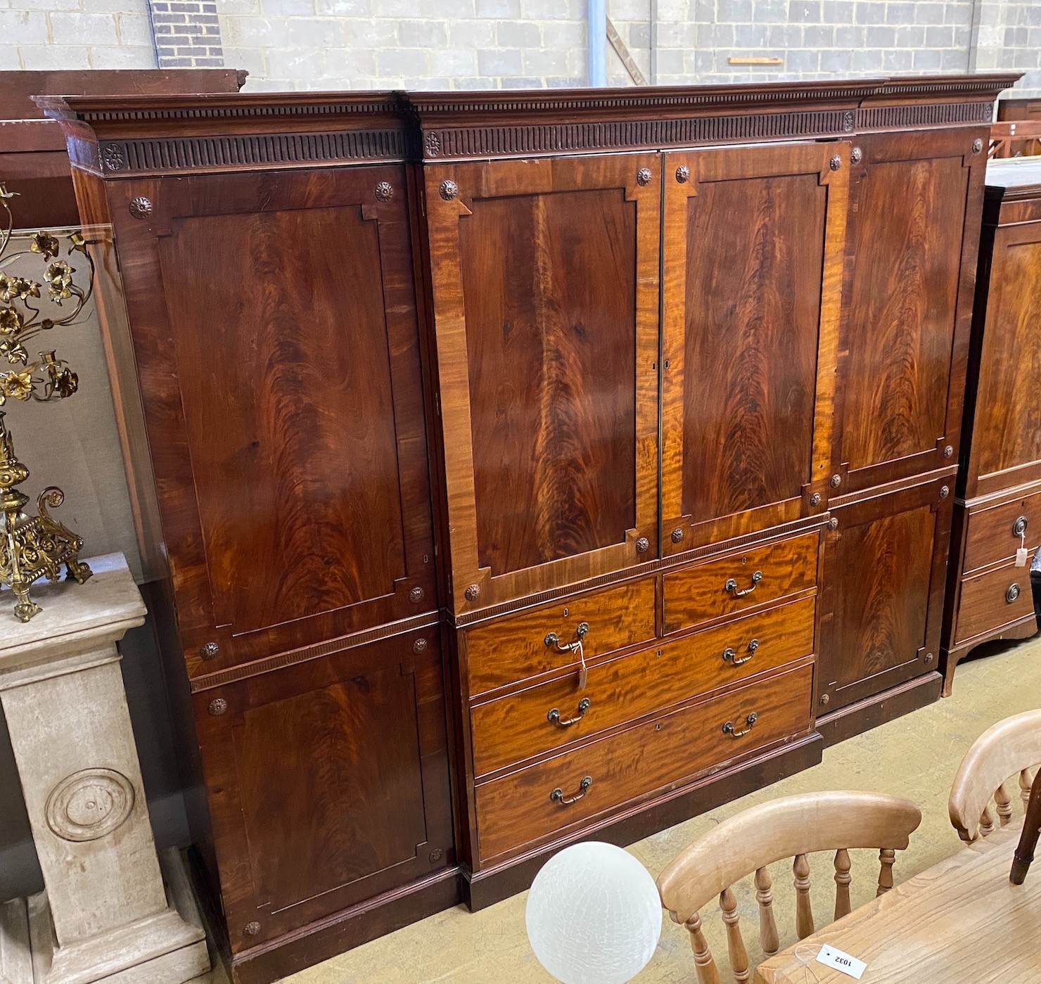 An Edwardian mahogany breakfront wardrobe, with two doors enclosing trays and four drawers flanked by hanging compartments, width 256cm, height 209cm